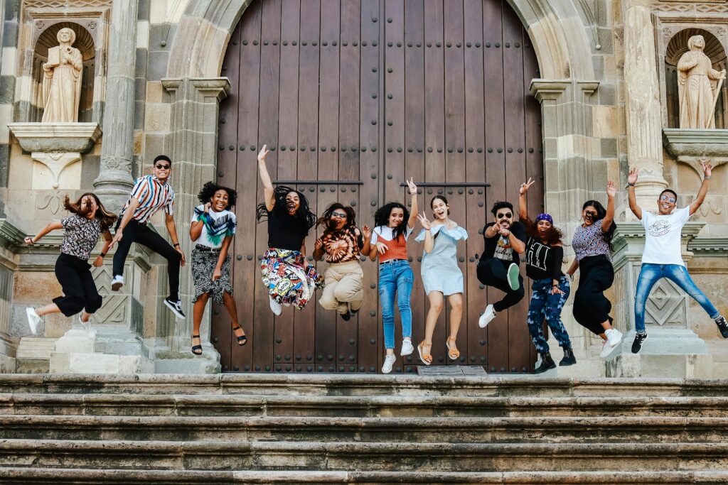 a pastor anniversary help celebrate. Crowd of young people jumping and celebrating their pastor outside a church